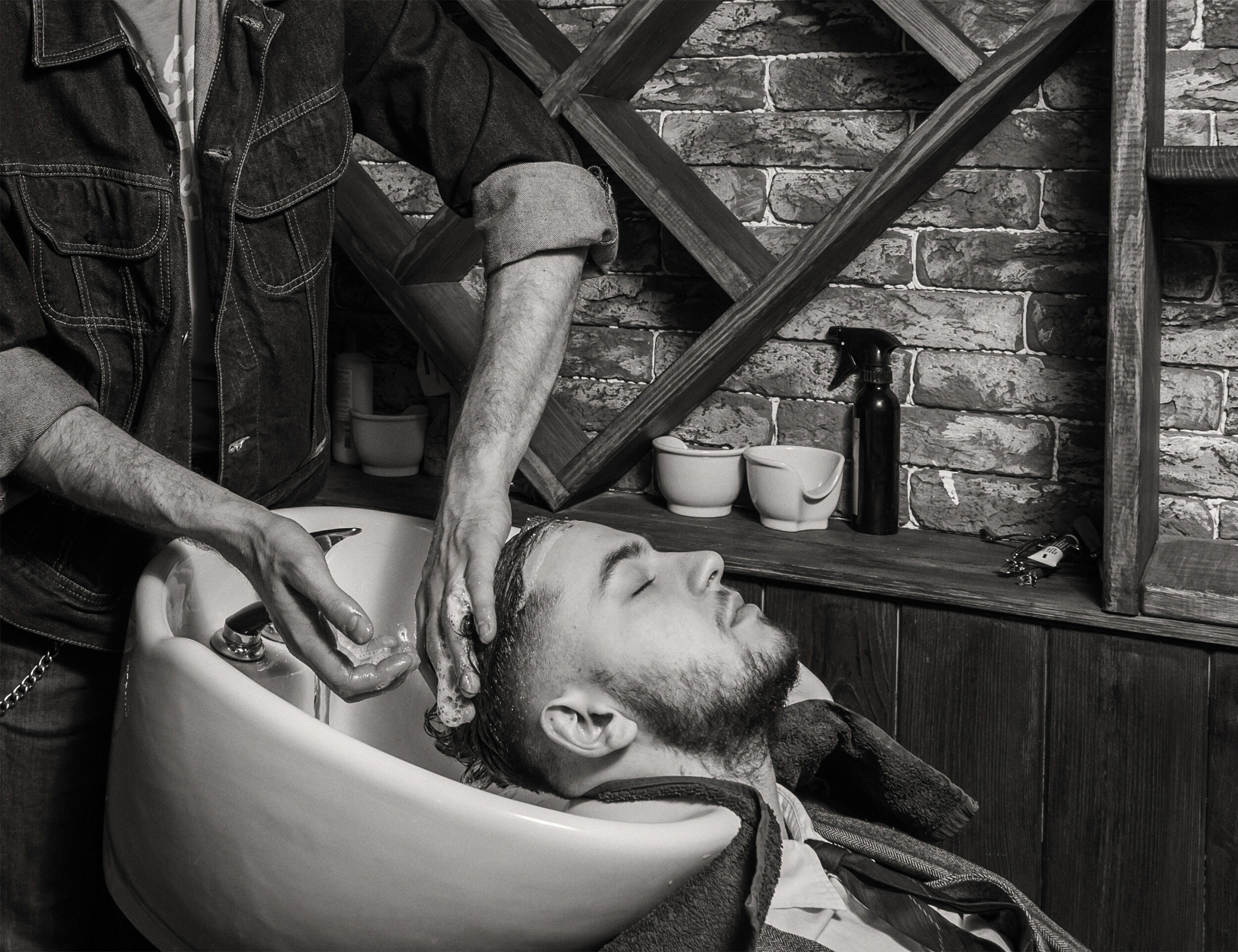 A groom getting hair conditioning done by a proffetionalist
